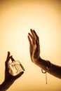 cropped view of woman spraying perfume on hand to feel fragrance,