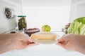 Cropped view of woman taking cheese from fridge with fruits and pickles Royalty Free Stock Photo