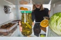 Cropped view of woman taking far with pickles from fridge shelf  on white Royalty Free Stock Photo
