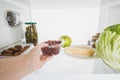 Cropped view of woman taking fresh currant from fridge with food Royalty Free Stock Photo