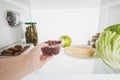 Cropped view of woman taking fresh currant from fridge with food  on white Royalty Free Stock Photo