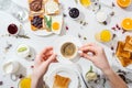 Cropped view of woman with tattoo on hand holding saucer and cup of espresso near breakfast on white . Royalty Free Stock Photo