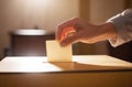 Cropped view of a womans hand putting her vote in the ballot box. Elections and voting day. Royalty Free Stock Photo