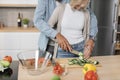 Cropped view of young attractive couple in love preparing salad from fresh vegetables. Royalty Free Stock Photo