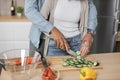 Cropped view of young attractive couple in love preparing salad from fresh vegetables. Royalty Free Stock Photo