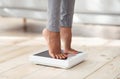 Cropped view of young black woman standing on scales at home, measuring her weight, closeup of feet Royalty Free Stock Photo