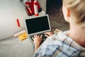 Cropped view of Young girl designer with laptop works in the repair place in the house. Choosing design new apartment concept Royalty Free Stock Photo