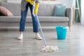 Cropped view of young housewife washing floor with mop at home, closeup of legs. Professional house cleanup concept Royalty Free Stock Photo