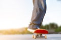 Cropped view of a young man skating on a skate park with black sneakers on a red skateboard - Extreme sport, friendship, youth