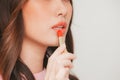 Cropped view of young woman applying orange lipstick Royalty Free Stock Photo