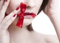 Cropped view of young woman with red ribbon tied over mouth against white background Royalty Free Stock Photo