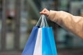 Cropped view of young woman in winter clothes holding bright gift bags outdoors, shopping for cold season, closeup Royalty Free Stock Photo