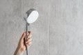 Cropped woman hand holding metal shining shower head