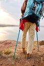 cropped woman nordic walking with trekking sticks on hill with beautiful river view. Royalty Free Stock Photo