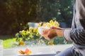 Cropped woman in pajama holding cup of her morning coffee or tea while having breakfast on the windowsill with the green Royalty Free Stock Photo