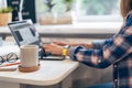 Cropped woman typing on laptop computer while sitting at home. Close up coffee cup and human hands. Distance learning Royalty Free Stock Photo