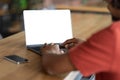 Cropped young african american guy blogger, student typing on computer keyboard with blank screen in cafe