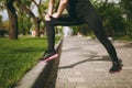 Cropped Young athletic girl in black uniform doing sport stretching exercises, warm-up before running or training Royalty Free Stock Photo