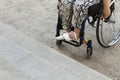 Cropped Young Disabled Adult Woman In Wheelchair In Front Of Stair On Sandy Path. Raising