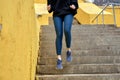 Cropped young female athlete running down the stairs, in sportive outfit Royalty Free Stock Photo