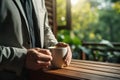 Cropper view of A businessperson holding a coffee cup stands on a wooden porch. AI Generated Royalty Free Stock Photo