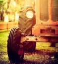 Old vintage red tractor standing on a farm field at sunset. Royalty Free Stock Photo