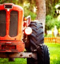 Old vintage red tractor standing on a farm field at sunset. Royalty Free Stock Photo