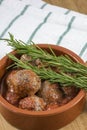 Croquettes in clay bowl with rosemary on kitchen towel