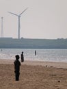 crosby beach with large wind turbine and anthony gormleys another place installation