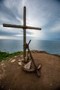Cross and anchor on the mountain on the background of sea and sky
