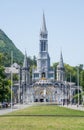 Cross and the Basilica of the Holy Rosary in Lourdes, France. Main facade of the Sanctuary at Lourdes