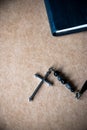 Cross and the Bible on brown paper background.