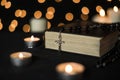 Cross on bible with candle lights and bokeh lights background Royalty Free Stock Photo
