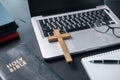 Cross on bible and laptop in online study bible concept. Holy Bible concept for modern religious education, podcast or help with Royalty Free Stock Photo