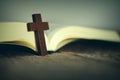 Cross on Bible on wooden table