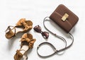 Cross body brown leather bag, suede wedge sandals and sunglasses on a light background, top view. Fashion concept Royalty Free Stock Photo