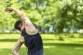 Cross-Body shoulder stretch. man doing workout in park outdoor. muscular guy stretching his arm. Royalty Free Stock Photo