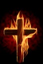 Cross burning or lighting concept theme with a wooden crucifix engulfed in fiery flames isolated on black background. It was used Royalty Free Stock Photo