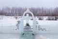 Cross carved from ice on a winter lake near the ice hole at Epiphany Royalty Free Stock Photo
