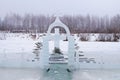 Cross carved from ice on a winter lake near the ice hole at Epiphany