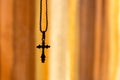 A cross on a chain on an orange background Royalty Free Stock Photo