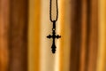 A cross on a chain on an orange background Royalty Free Stock Photo