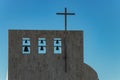 Cross on church over clear blue sky. Six bells of different sizes on the top. Adeje village, Tenerife, Spain Royalty Free Stock Photo