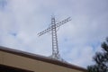 Cross on church roof top with a blue and white sky in background Royalty Free Stock Photo