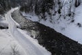 Cross-country ski trails in a snowy path next to a small river Royalty Free Stock Photo