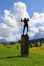 A cross-country skier bronze statue stands on the meadow ot Compatsch, Dolomites