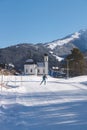 Cross-country skier on sunny sport track towards pitoresque church, Seefeld, Austria Royalty Free Stock Photo