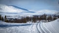 Cross country skiing. Empty touring ski trail. Snowy mountains in the background