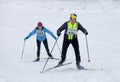 Cross country skiing man wearing swedish hat and woman skiing up Royalty Free Stock Photo
