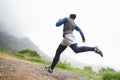 Cross country training. A young man running in rugged outdoors.